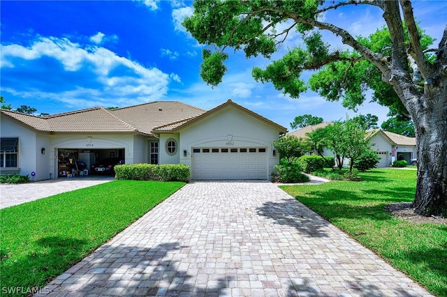 ranch-style house featuring a garage and a front lawn