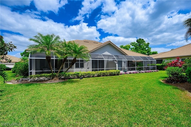 back of house with a lanai and a yard