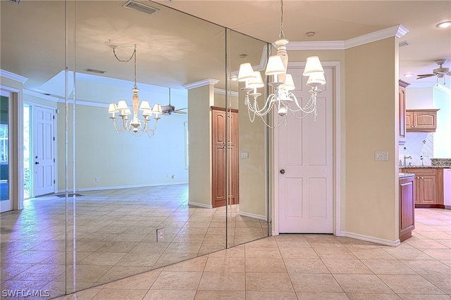 unfurnished dining area featuring ceiling fan with notable chandelier, light tile patterned floors, and ornamental molding