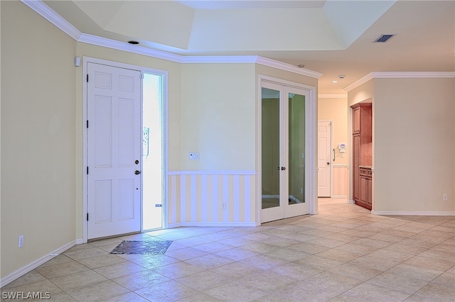 tiled entrance foyer featuring french doors, ornamental molding, and a tray ceiling