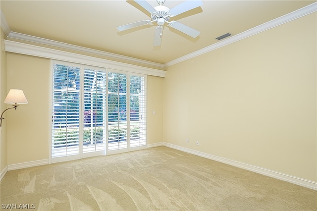 empty room featuring ceiling fan, light colored carpet, and crown molding