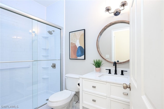 bathroom with vanity, a shower with shower door, and toilet