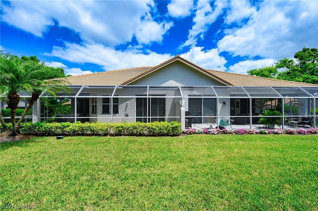 back of house featuring a lanai and a lawn