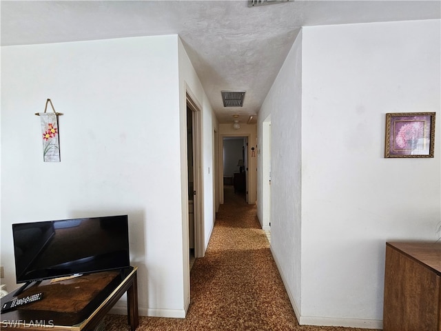 hallway with dark colored carpet