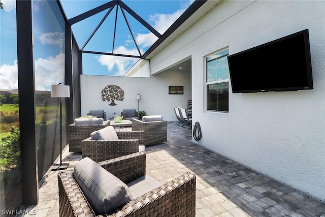 view of patio / terrace featuring outdoor lounge area and glass enclosure