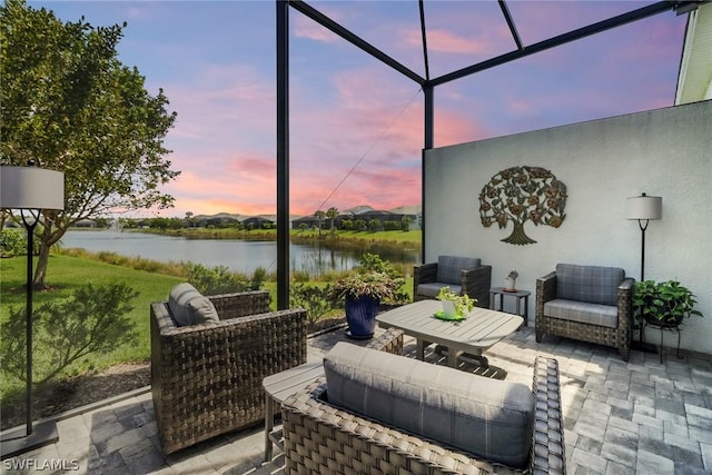 patio terrace at dusk with a water view and glass enclosure