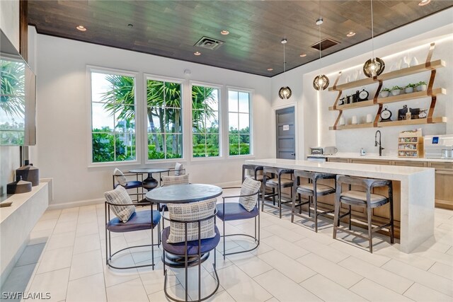 dining room with light tile patterned floors, sink, and wooden ceiling