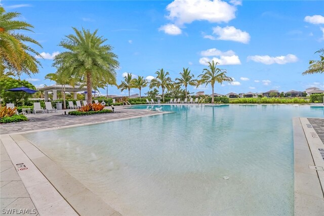 view of pool featuring a patio and a water view