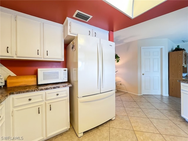 kitchen with white cabinets, white appliances, and light tile floors