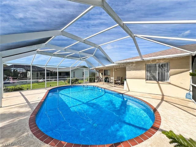 view of swimming pool featuring a patio area and glass enclosure