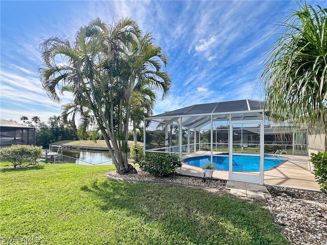 view of swimming pool featuring a lanai and a lawn