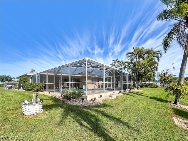 rear view of property with glass enclosure and a yard