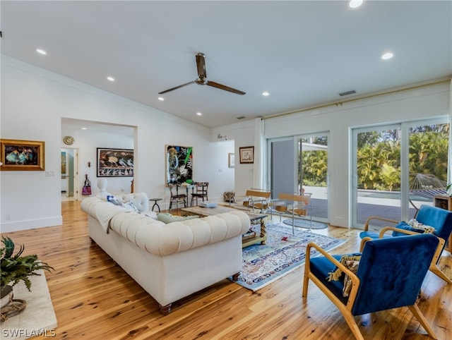 living room with crown molding, ceiling fan, and light wood-type flooring