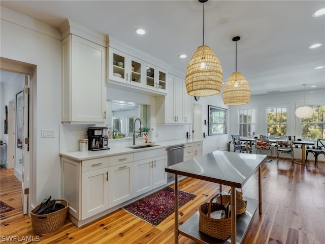 kitchen with hanging light fixtures, white cabinets, and sink