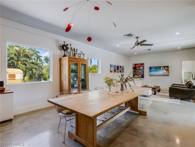 dining space featuring concrete floors and ceiling fan