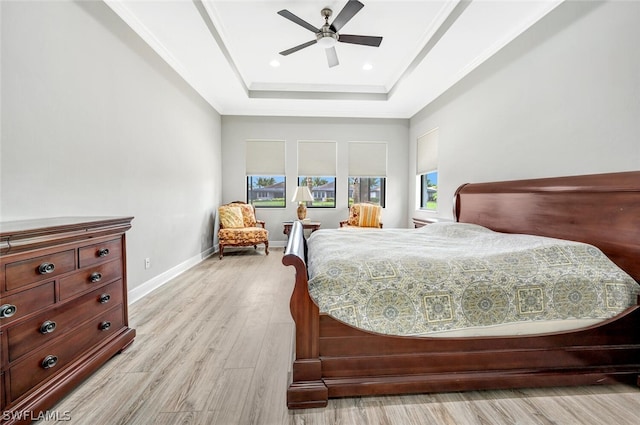 bedroom with ornamental molding, a raised ceiling, light hardwood / wood-style floors, and ceiling fan