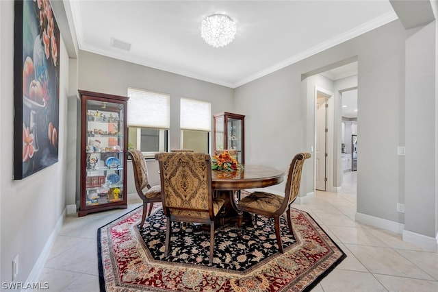 dining area with light tile floors, a notable chandelier, and ornamental molding