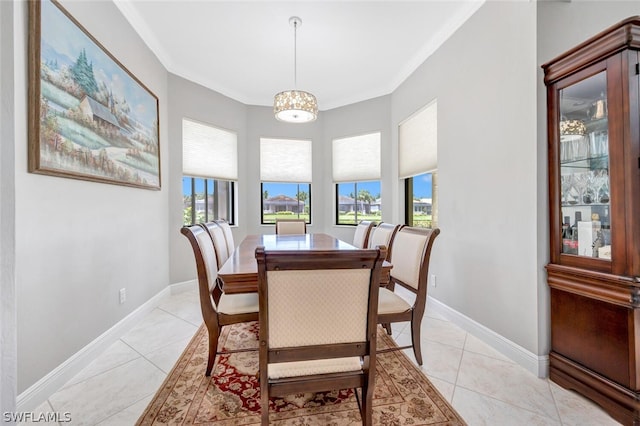 tiled dining room with a notable chandelier and crown molding