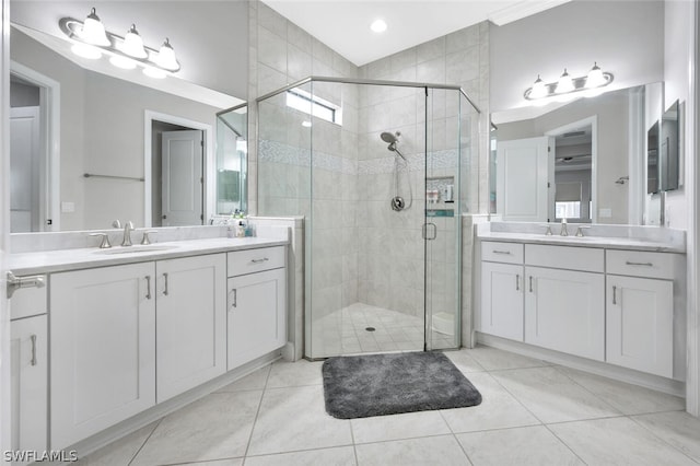 bathroom featuring tile floors, vanity with extensive cabinet space, dual sinks, and walk in shower