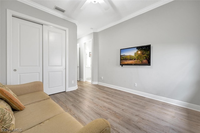 living room featuring light hardwood / wood-style flooring, ceiling fan, and crown molding