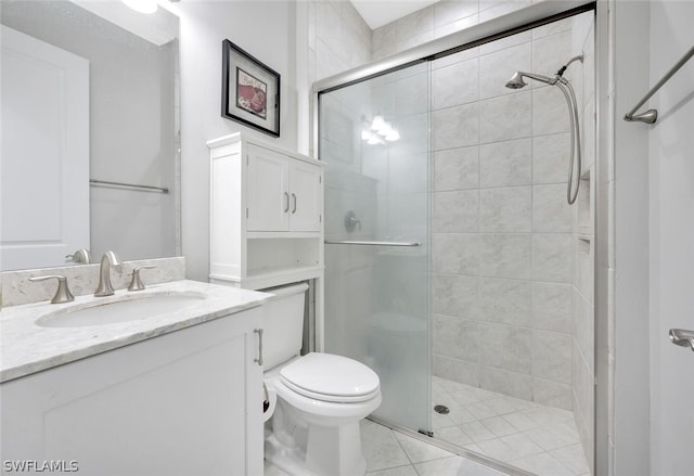 bathroom featuring toilet, large vanity, tile floors, and a shower with shower door