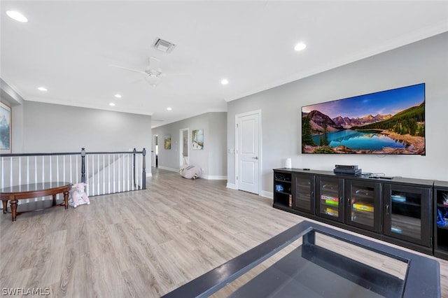 living room featuring ornamental molding, ceiling fan, and light hardwood / wood-style flooring