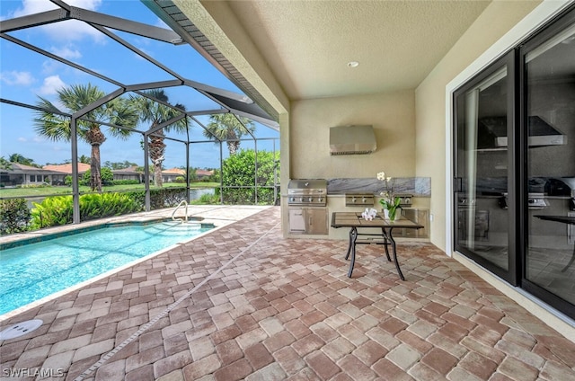 view of swimming pool featuring exterior kitchen, a grill, a patio, and a lanai