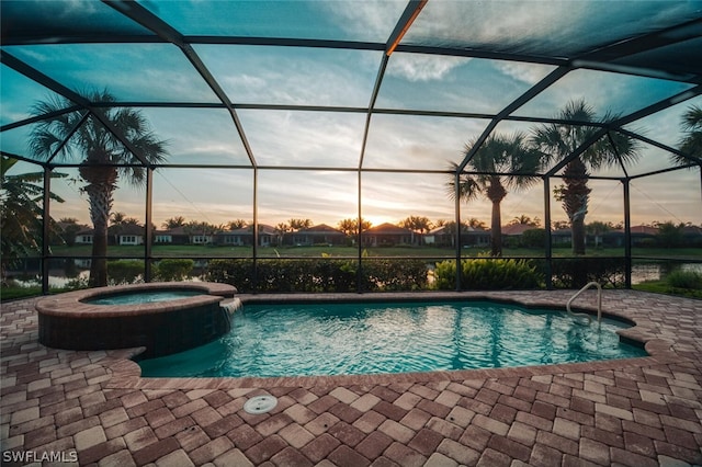 pool at dusk with a patio area, an in ground hot tub, and a lanai