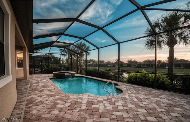 pool at dusk with a patio, an in ground hot tub, and a lanai