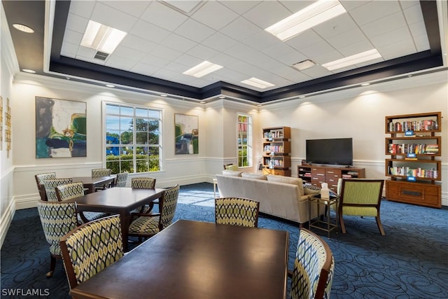 carpeted dining space with ornamental molding and a raised ceiling