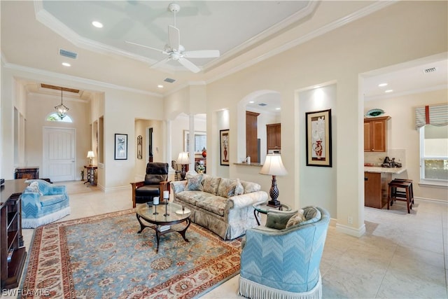 living room featuring light tile patterned floors, crown molding, and ceiling fan