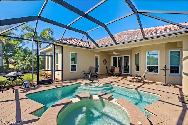 view of pool with a lanai, a patio, ceiling fan, and an in ground hot tub