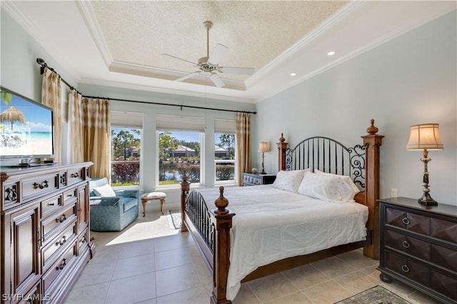 bedroom with a raised ceiling, crown molding, light tile patterned floors, and a textured ceiling