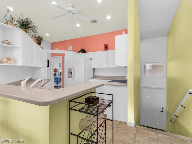 kitchen featuring white refrigerator with ice dispenser, white cabinets, ceiling fan, and light tile floors