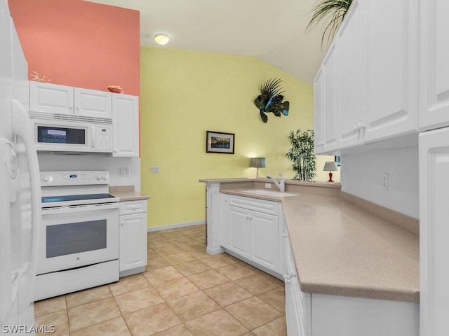 kitchen with vaulted ceiling, white appliances, light tile floors, and white cabinetry