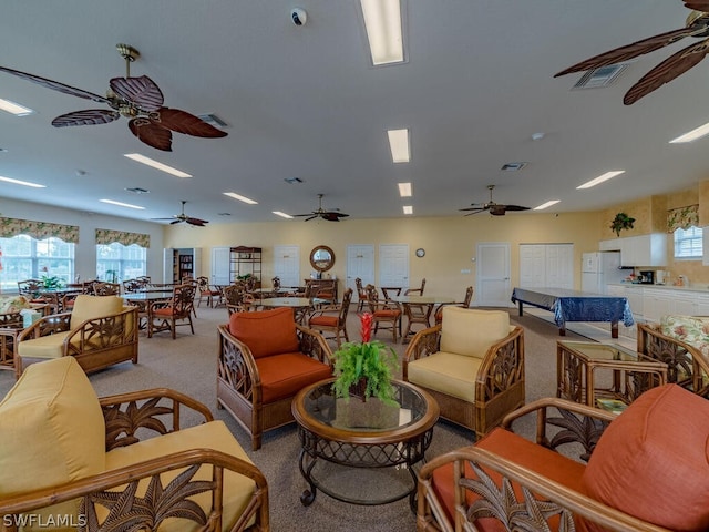 living room featuring ceiling fan, a wealth of natural light, and light colored carpet