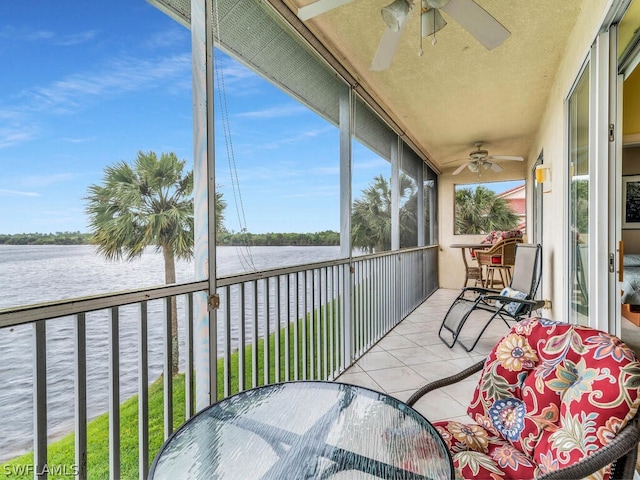 sunroom featuring a water view, ceiling fan, and plenty of natural light