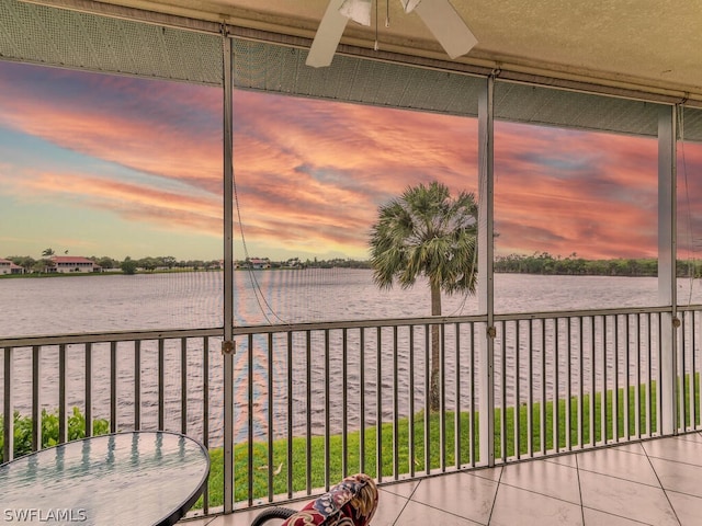 unfurnished sunroom with a water view and ceiling fan