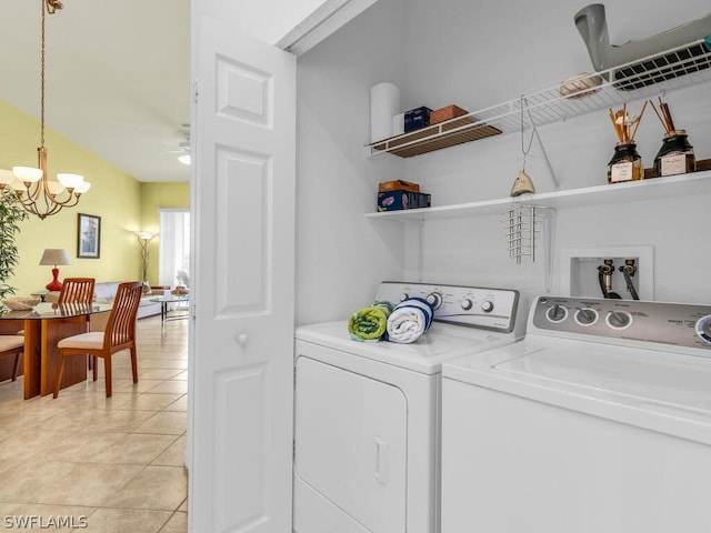 clothes washing area featuring washer and dryer, washer hookup, light tile floors, and ceiling fan with notable chandelier