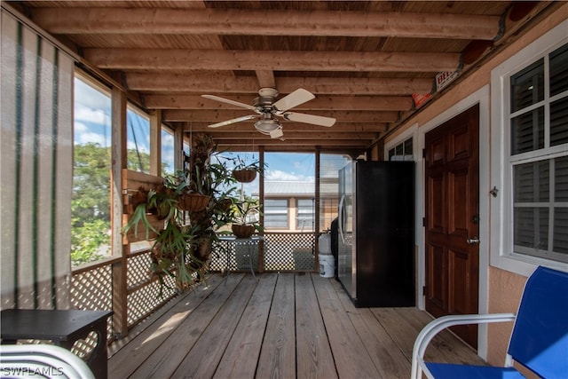 unfurnished sunroom with beamed ceiling, wooden ceiling, plenty of natural light, and ceiling fan