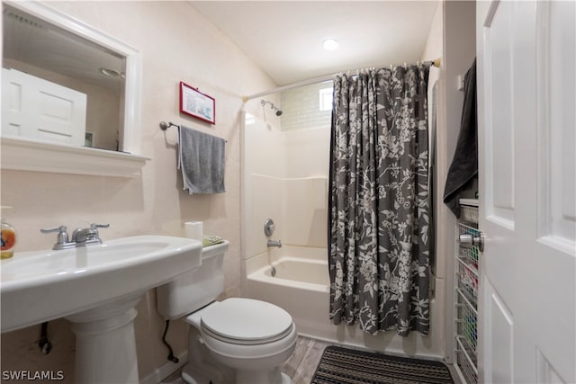 bathroom with shower / bathtub combination with curtain, hardwood / wood-style floors, and toilet