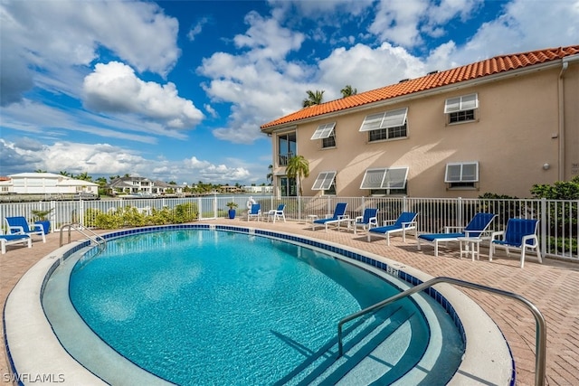 view of swimming pool featuring a wall mounted air conditioner and a patio