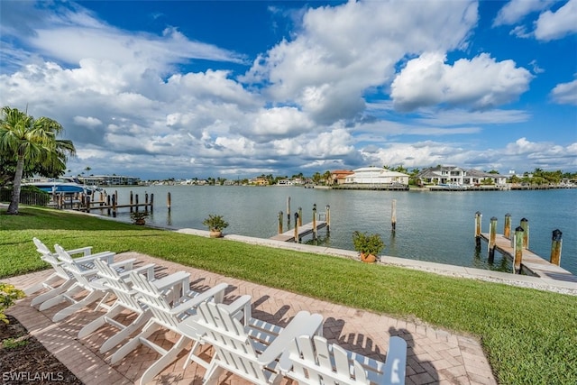 view of dock with a yard and a water view