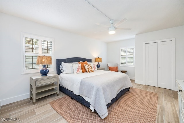 bedroom with ceiling fan, light wood-type flooring, and a closet