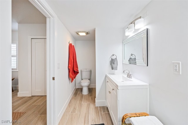 bathroom featuring toilet, vanity, and hardwood / wood-style flooring