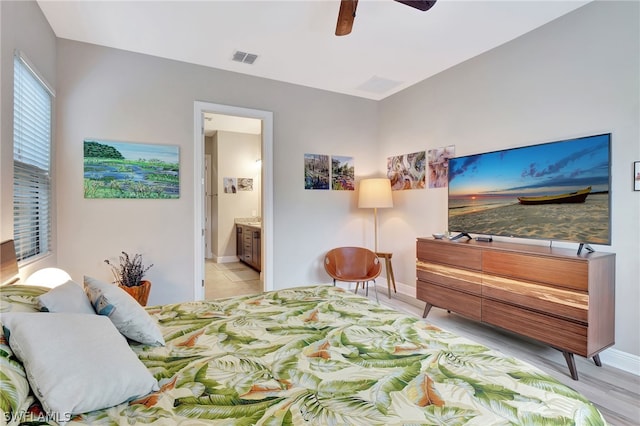 bedroom featuring a ceiling fan, visible vents, connected bathroom, and baseboards