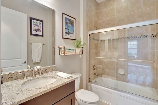 full bathroom with vanity, toilet, and bath / shower combo with glass door