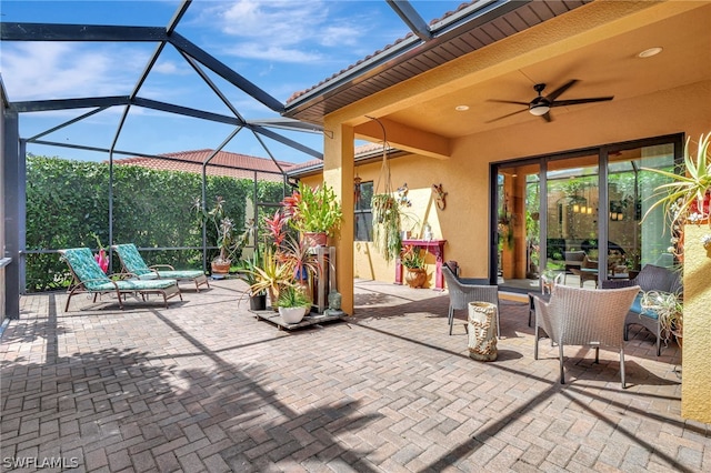 view of patio with glass enclosure and ceiling fan