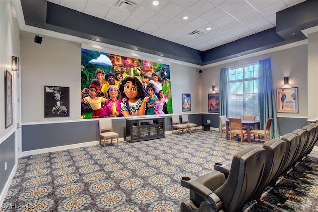 carpeted home theater with a raised ceiling, visible vents, and baseboards