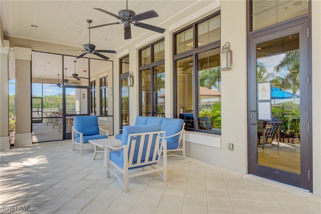 sunroom featuring wooden ceiling and a ceiling fan